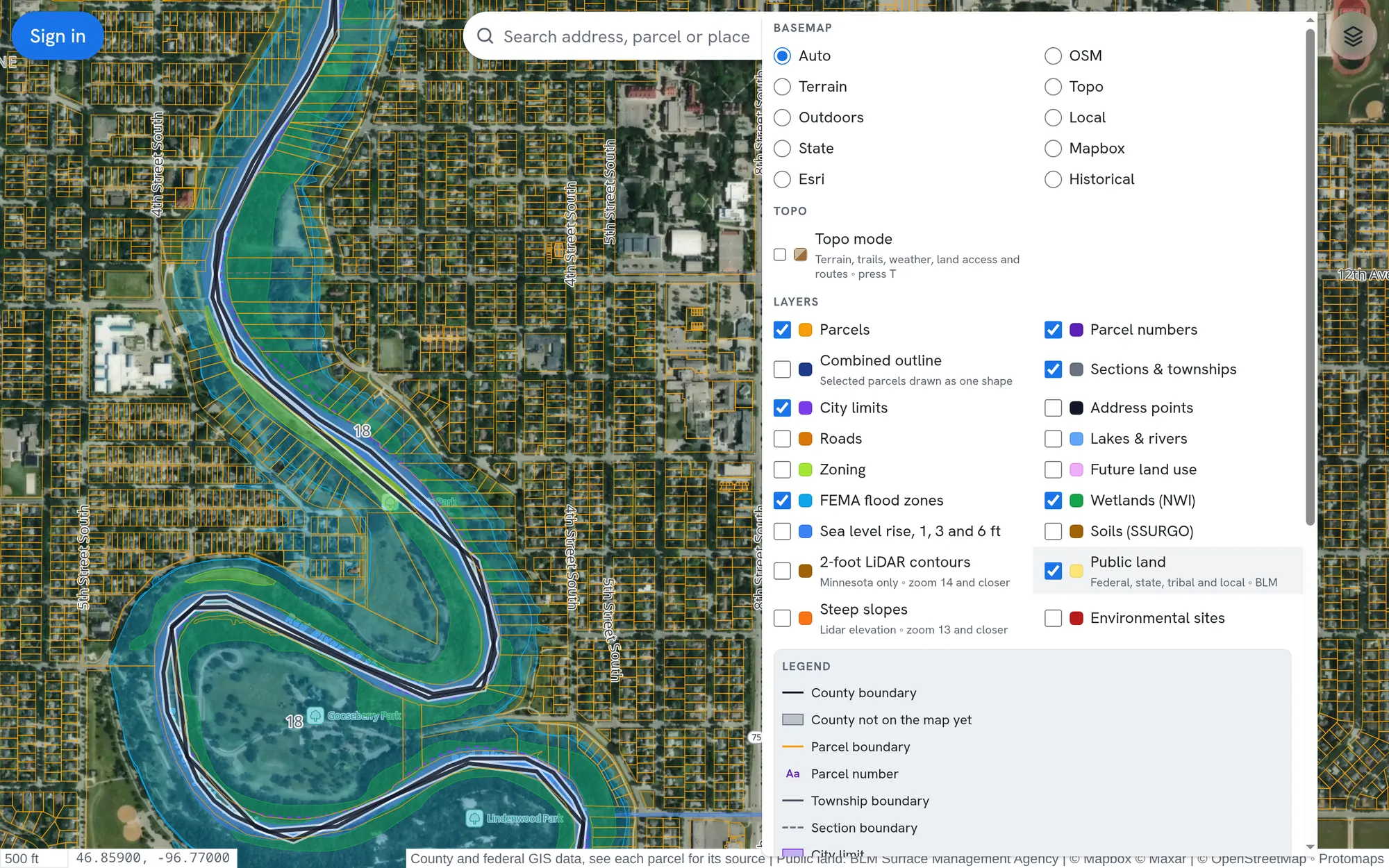 Flood zones and wetlands shaded along the Red River in Moorhead, Minnesota, with the map layers panel open